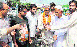 Youths felicitate a poor 70-year-old rickshaw-puller on Dasehra festival in Haridwar on Sunday
