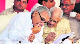 Chief Minister Bhupinder Singh Hooda and Labour Minister Shivcharan Sharma discuss a point during a public rally in Faridabad on Sunday.