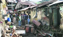 Onlookers gather around the houses damaged in a blast caused by a leak in a gas cylinder at Jutogh near Shimla on Sunday.