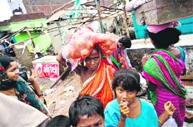 People with their belongings wait to return to Sonupur village, in Gopalpur (Odisha), on Sunday