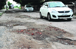 A damaged road near the Army flats at Mansa Devi Complex in Panchkula. Tribune Photo: Nitin Mittal