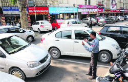 A guard helps a visitor park a car at the Sector 22-D market. Tribune photo: Manoj Mahajan