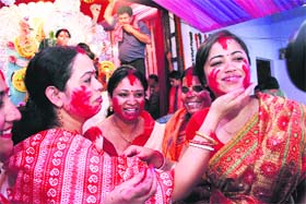 Bengali women apply vermilion to each other on the conclusion of Durga Puja in Dehradun on Monday