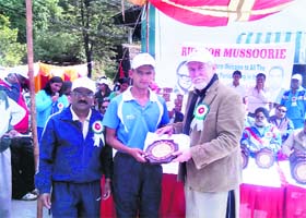 Bollywood actor Tom Alter presents an award to a winner in Mussoorie on Monday