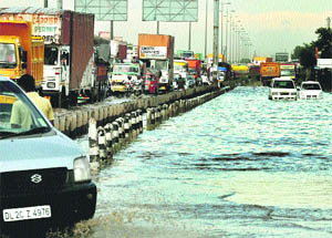 Commuters face inconvenience as water accumulates after the rain at the Delhi express highway in Gurgaon. 