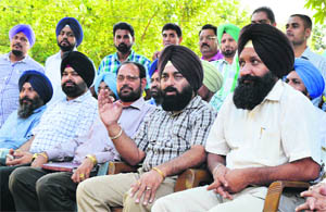 Rupinder Singh, president of the Patwari Association, (second from right) speaks during the protest in Ludhiana on Monday. 