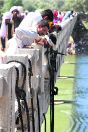 People look for survivors from the bridge over Sindh river near Ratangarh temple in Datia on Monday.