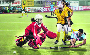 Sukhjit Kaur (right) of Punjab XI (India) tries to score against Punjab XI (Pakistan) in the Surjit Hockey tournament on Monday. The Indian team won 7-2. 