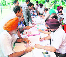 MC House Tax Department team conducts an awareness camp on property tax at Basant Avenue Park in Amritsar on Tuesday.