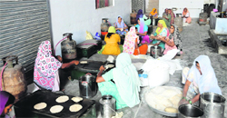 Women prepare rotis at the Bishalakshmi Club centre, where the mid-day meal for 48 schools is cooked every morning in Bathinda. Tribune photo: Pawan Sharma