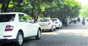 Vehicles parked outside the parking area on the main road at Sector 11 in Panchkula.