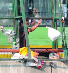 PUJA TIME OVER: A woman throwing the waste after the Navratri festival in New Delhi on Tuesday