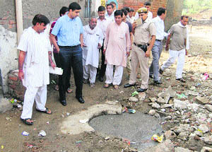 Deputy Commissioner Chander Shekhar inspects overflowing sewage in Ward 6 of Sonepat on Tuesday. 