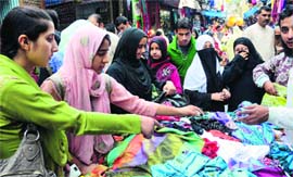 Women buy clothes on the eve of Eid-ul-Azha in Srinagar on Tuesday.
