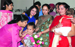 Amrita Kaur, a thalasaemic child, being cuddled by Geeta Gupta, president of the Luxmi Ladies Club. Amrita's 11-month-old bone marrow donor, her own sister Rehmat Kaur, is in the lap of her mother. A Tribune Photograph