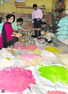 Health officials inspect the raw material used in the preparation of sweets at the unit. 