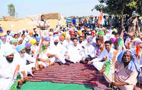 District Congress leaders and their supporters stage a dharna with farmers at the grain market in Amritsar on Wednesday.