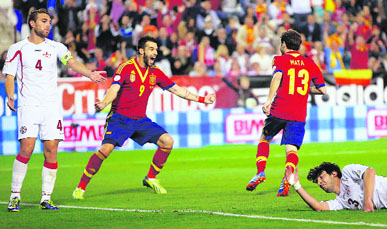 Spains Juan Mata (right) celebrates his goal with teammate Alvaro Negredo next to Georgias Giorgi Khidesheli (on ground) during their 2014 World Cup qualifying match in Albacete, Spain, on Tuesday night. 