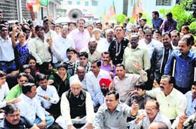 BJP workers hold a demonstration, demanding check dams and better facilities in the colonies on river banks at the DMs office in Dehradun on Thursday