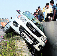 The car that got stuck in an open drain on the NH-1 in Ludhiana