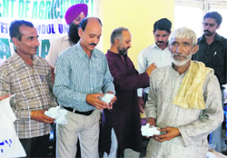 Officials of the Agriculture Department distribute free seeds to a farmer at an awareness camp held at Bagga village in Reasi on Friday. A Tribune Photograph