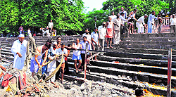 Volunteers of the Teerth Maryada Raksha Samiti and Small-Scale Traders Association members clean the Birla ghat in Haridwar on Saturday