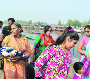Tourists enjoy a walk on the banks of the Dal Lake in Srinagar on Saturday.