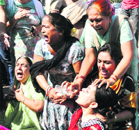 Family members of main accused Harvinder Singh Bagga in an aggressive mood during a protest outside the Dugri police station in Ludhiana on Saturday. Tribune Photo ; Himanshu Mahajan