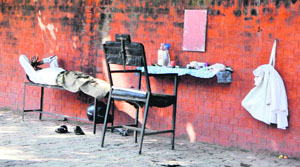 A roadside barber takes a nap on Sunday afternoon.