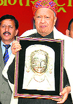 Chief Minister Virbhadra Singh being presented a memento by the Kullu Dasehra Committee in Kullu on Sunday