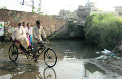 Commuters near Ikhari Pulli in Jalandhar on Sunday. A Tribune photograph