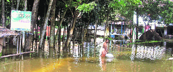 A man wades through knee-deep water in Midnapore of West Bengal on Sunday.  PTI