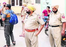 Police officials stand outside Agarwal Guest House, where a Ludhiana youth committed suicide, in Amritsar on Monday
