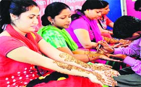 FOR HIS LONG LIFE: Women get mehndi applied on their hands on the eve of Karwa Chauth in Haridwar on Monday