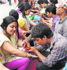 Women get henna applied on their hands on the eve of Karva Chauth in Gurgaon on Monday. 