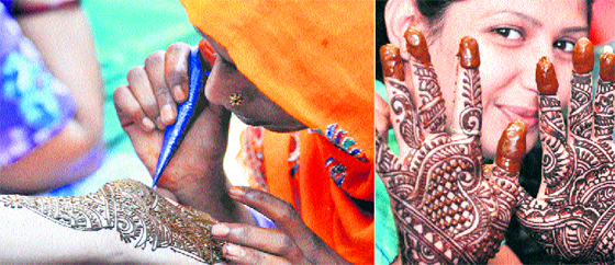 A woman applies mehndi to a customer; and (right) a girl shows her mehndi on the eve of Karva Chauth in Jammu on Monday.