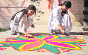 Students prepare rangoli during the exhibition-cum-sale organised by the Home Science Department of Government College for Women, Gandhi Nagar, on the college premises in Jammu on Monday.