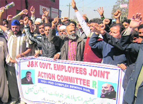 Employees raise anti-government slogans during a protest in Srinagar on Monday.