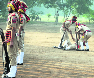 Policemen support their colleague who fainted during the Police Commemoration Day parade in Ludhiana on Monday. Tribune photo: Himanshu Mahajan