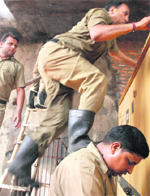 A firefighter tries to scale a wall with the help of his colleagues. a file photograph