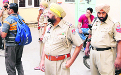 Police officials stand outside Agarwal Guest House, where a Ludhiana youth committed suicide, in Amritsar on Monday. Tribune photo: Vishal Kumar