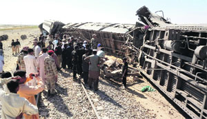 People looks at derailed train in Balochistan.