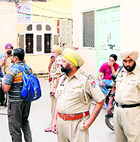 Police officials stand outside Agarwal Guest House, where a Ludhiana youth committed suicide, in Amritsar on Monday