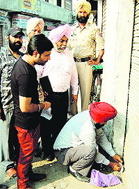 A house tax team of the MC seals a building at Partap Nagar in Amritsar on Tuesday