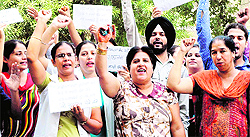 Members of the Nursing Association raise slogans against the government in support of their demands at Guru Nanak Dev Hospital in Amritsar on Tuesday