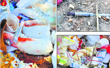 Blood-stained bandages, a used syringe and other bio-medical waste disposed of in the open.