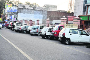 Vehicles parked on the road due to lack of parking space in Gole Market area of Jammu on Tuesday. 