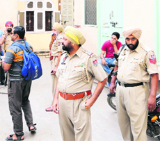 Police officials stand outside Agarwal Guest House, where a Ludhiana youth committed suicide, in Amritsar. 