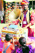 A man from Rajasthan entertains children and others with a bioscope at the Saras Mela in Sangrur on Tuesday