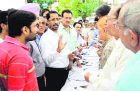 Local Bodies Minister Anil Joshi talks to residents about the property tax structure during the awareness-cum-recovery camp organised at Medical Enclave in Ward 9 in Amritsar on Wednesday